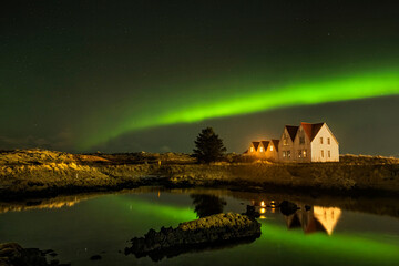 Fototapeta premium Panoramic night views of northern lights or polar lights appear over villages in Iceland