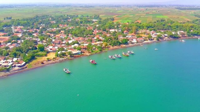 Coastline in a Small Town in East Java. It is one of the fishing villages in the area. Producing snacks from seafood, the name of the food is rengginang. This video was taken using an aerial drone 4K.