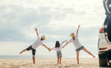 Happy family three is standing hand in hand on sandy beach, Parents father and mother holding hands their children back car, holiday vacations summer road trip, Family day enjoying their time together