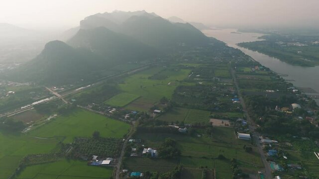 Aerial fly Foggy tropical Thailand landscape, Kanchanaburi Village, agricultural fields of Southeast Asia