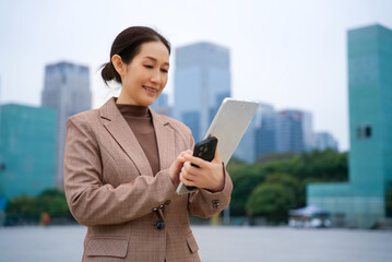 Confident Businesswoman Engaging with Technology in Urban Landscape