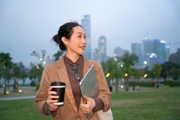 Confident Professional Woman with Coffee in Urban Setting at Dusk