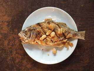 fried whole False Trevally fish with garlic
