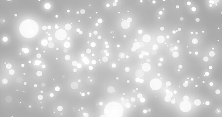 Image of white glowing spots falling on grey background