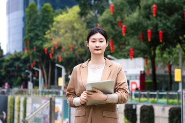 Confident Businesswoman Holding a Tablet in a Modern Urban Environment