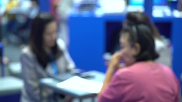 An event where attendees come to negotiate business, finance, investment, insurance. Blur focus, soft focus, slight camera shake.
