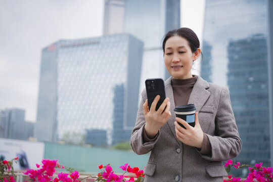 Professional Woman Enjoying Coffee and Using Smartphone in Urban Setting