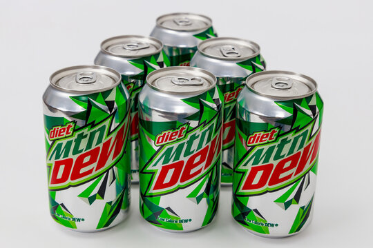 March 6, 2023. Spartanburg, SC USA. Group of seven Mountain Dew diet soda cans displayed in circular formation on plain white surface.