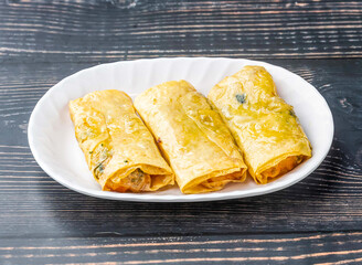 Shrimp and Bean Curd Rolls served in tray dish isolated on wooden table side view of hong kong food
