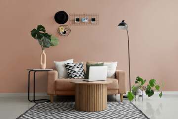 Interior of modern living room with grey sofa, laptop on coffee table and mood board