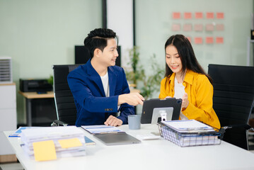 Two business workers talking on the smartphone and using laptop