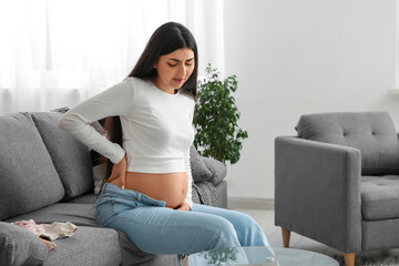Beautiful pregnant woman feeling back pain at home