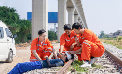 paramedic team first aid help emergency accident patient suffered on head at rail tracks and walkie talkie communicate for refer to hospital