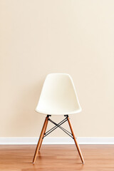 Stylish white chair against a light wall in a modern interior setting