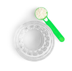 Green plastic scoop with collagen powder and glass of water on white background