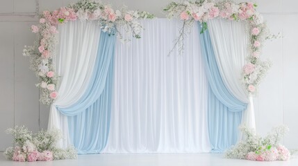 Elegant backdrop with draped fabric and floral arrangements for events.