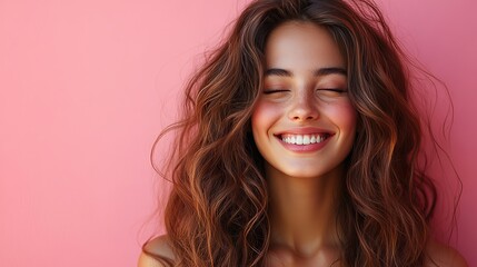 Naklejka premium A woman with flowing hair smiles with her eyes closed against a pink background, embracing the freedom and joy of healthy hair and radiating beauty and confidence.