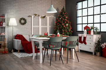 Interior of modern dining room with table, sofa and Christmas tree