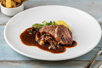 Grilled beef tenderloin with Demi glace sauce with grilled vegetables on a white porcelain plate