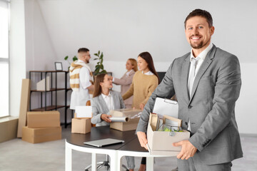 Businessman with box of things in office on moving day