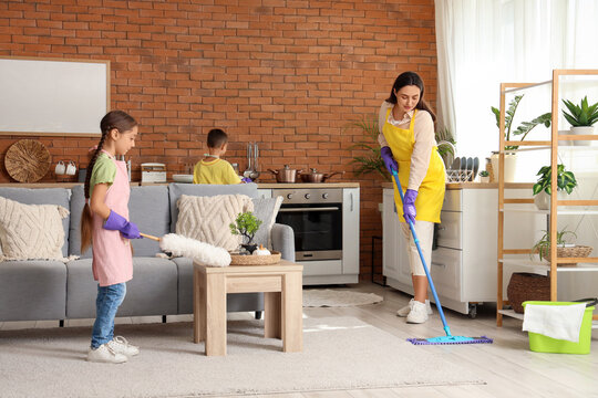 Cute little children helping their mother with cleaning routine at home