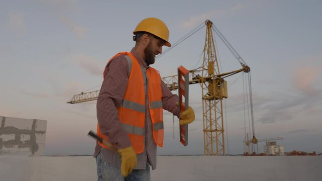 Funny construction worker dancing. Positive dance of builders in helmet. Construction engineer in builder uniform dancing on his work place