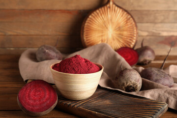 Bowl with beet powder on wooden background