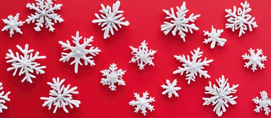 White snowflakes arranged artistically on a vibrant red background showcasing winter's beauty and festive spirit in a striking contrast.