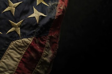 Close-up detail of a heavily worn and stained American flag.