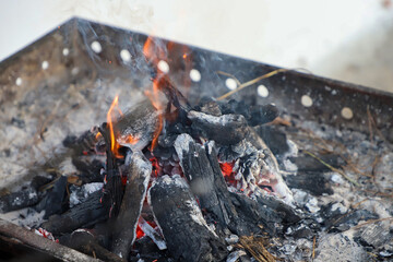 Man preparing traditional BBQ charcoal fire using special apparatus for grilling, with a close-up...