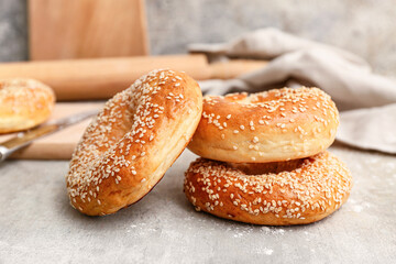 Tasty bagels with sesame seeds on grey background