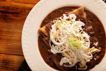Enfrijoladas. Corn tortillas dipped in bean sauce, covered with cream and cheese, they can be covered or filled with chicken meat, cheese or some other ingredient. Traditional Mexican dish.