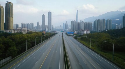 Fototapeta premium Empty Highway Through Urban Skyline, Mountains in Background