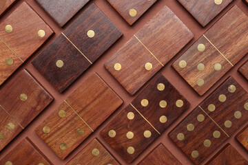 Many wooden dominos blocks on brown background
