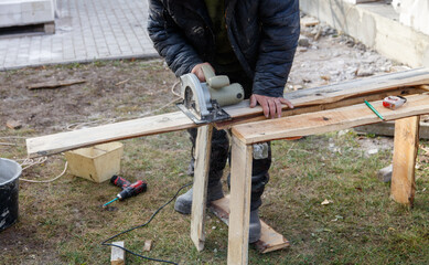 A man is using a saw to cut a piece of wood