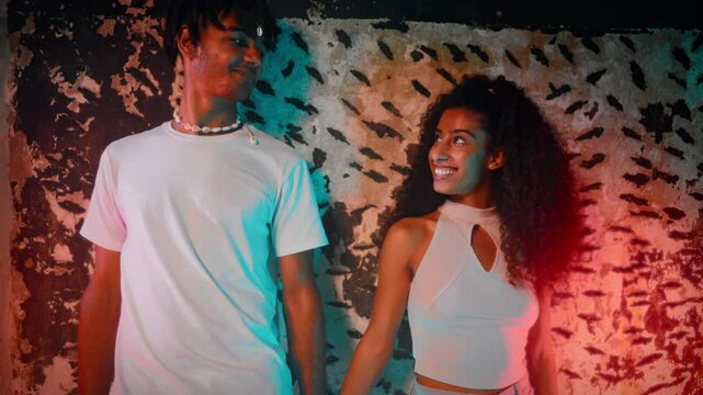 Happy lovers flirting, smiling and looking in eyes, multiracial relationships. Attractive young people of Africana American and Arab ethnicity, romantic mood, pretty woman and boyfriend holding hands