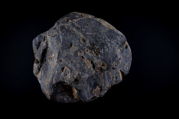 Beautiful rounded stone on a black background. Wet stone, pebbles, cobblestones.