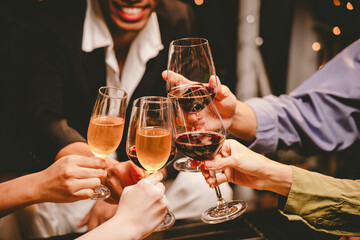 A group of friends enjoy an outdoor evening, drinking wine in a friendly and lively atmosphere. They celebrate togetherness, happiness and bonding.