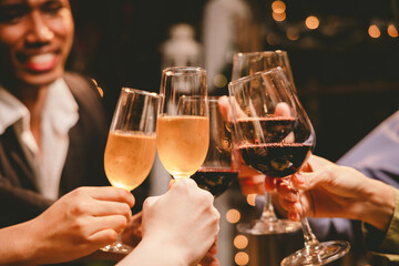 A group of friends enjoy an outdoor evening, drinking wine in a friendly and lively atmosphere. They celebrate togetherness, happiness and bonding.