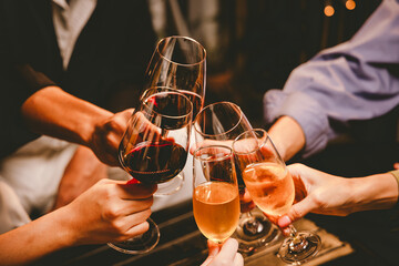 A group of friends enjoy an outdoor evening, drinking wine in a friendly and lively atmosphere. They celebrate togetherness, happiness and bonding.