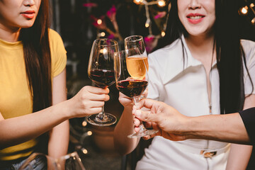 A group of friends enjoy an outdoor evening, drinking wine in a friendly and lively atmosphere. They celebrate togetherness, happiness and bonding.