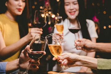 A group of friends enjoy an outdoor evening, drinking wine in a friendly and lively atmosphere. They celebrate togetherness, happiness and bonding.