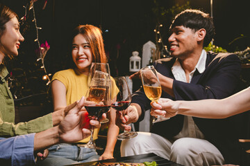 A group of friends enjoy an outdoor evening, drinking wine in a friendly and lively atmosphere. They celebrate togetherness, happiness and bonding.
