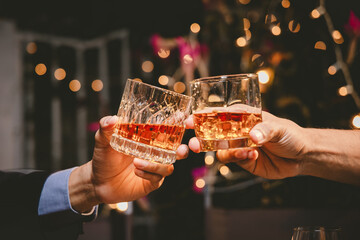 A group of friends enjoy an outdoor evening, drinking wine in a friendly and lively atmosphere. They celebrate togetherness, happiness and bonding.