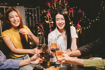 A cheerful group of friends enjoying wine and food on a sunny patio. Toasting with wineglasses, they celebrate togetherness in a scenic outdoor setting, blending fun, friendship, and a festive mood.