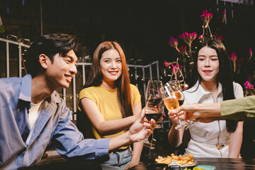 A joyful group of friends and family gathered around a dinner table, raising wine glasses in a celebratory toast. Smiling and laughing, they enjoy food, drinks, and togetherness in a festive atmospher