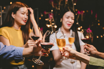 A joyful group of friends and family gathered around a dinner table, raising wine glasses in a celebratory toast. Smiling and laughing, they enjoy food, drinks, and togetherness in a festive atmospher