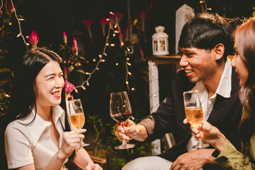 A joyful group of friends and family gathered around a dinner table, raising wine glasses in a celebratory toast. Smiling and laughing, they enjoy food, drinks, and togetherness in a festive atmospher