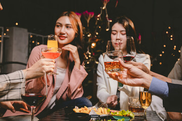 A group of cheerful friends enjoy drinks at a joyful celebration. They smile and laugh, sharing moments of happiness, togetherness and relaxation in a lively social atmosphere.