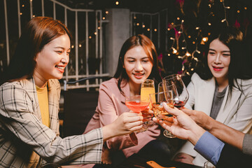 A group of cheerful friends enjoy drinks at a joyful celebration. They smile and laugh, sharing moments of happiness, togetherness and relaxation in a lively social atmosphere.